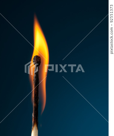 burning match with tongue of flame on blue 92551373