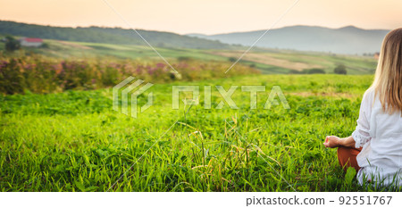 Woman doing yoga on the green grass at the mountain. Carpathians 92551767
