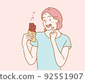 Young woman eating chocolate bar. Hand drawn in thin line style, vector illustrations. 92551907
