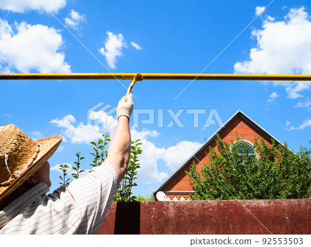 peasant paints outdoor gas pipeline in village peasant paints outdoor gas pipeline in village 92553503