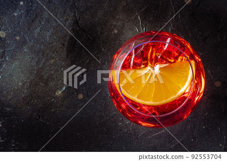 Aperol cocktail with a fresh orange slice, Italian summer cold drink Aperol cocktail with a fresh orange slice, Italian summer cold drink 92553704