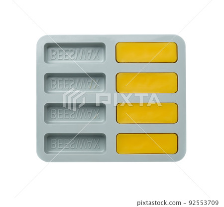 Natural beeswax. Cast beeswax bars in a silicone mold on a white background. Beekeeping products. Natural beeswax. Cast beeswax bars in a silicone mold on a white background. Beekeeping products. 92553709