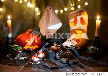 Halloween pumpkin with burning mouths, candles, drinks and sweets. Halloween pumpkin with burning mouths, candles, drinks and sweets. 92553758