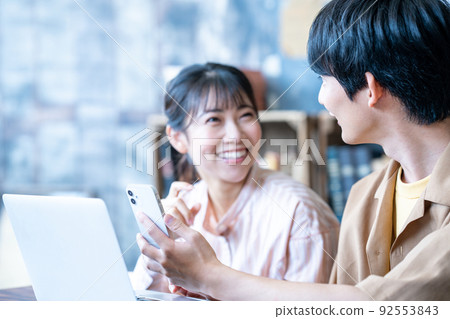Couple using laptop and smartphone Couple using laptop and smartphone 92553843