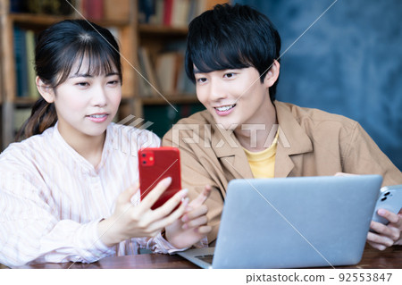 Couple using laptop and smartphone Couple using laptop and smartphone 92553847