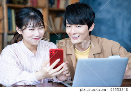 Couple using laptop and smartphone Couple using laptop and smartphone 92553848