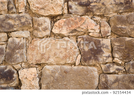 Masonry walls of natural sand color. Stone texture close-up, construction and mining background. 92554434