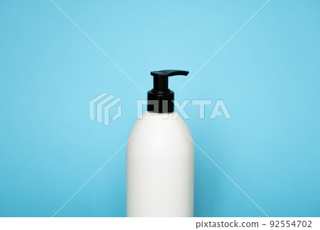 White plastic soap dispenser pump bottle isolated on blue background. Skin care lotion. Bathing essential product. Shampoo bottle. Bath and body lotion. Fine liquid hand wash. Bathroom accessories. White plastic soap dispenser pump bottle isolated on blue background. Skin care lotion. Bathing essential product. Shampoo bottle. Bath and body lotion. Fine liquid hand wash. Bathroom accessories. 92554702