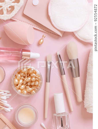 Natural skin care products and decorative cosmetics on light pink, top view 92554872