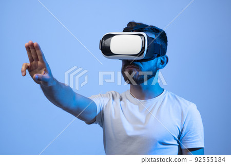 Closeup portrait of a man wearing VR goggles, working over virtual project, enjoying new reality, playing video game. Technology, innovation gadgets. Closeup portrait of a man wearing VR goggles, working over virtual project, enjoying new reality, playing video game. Technology, innovation gadgets. 92555184