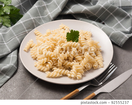 boiled fusilli pasta decorated with greenery in a cafe boiled fusilli pasta decorated with greenery in a cafe 92555237
