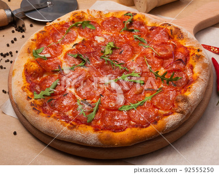 pepperoni pizza on thick dough decorated with arugula 92555250
