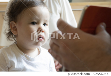 Half kid looking at the screen of a PC tablet 92556053