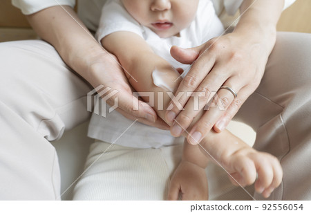 Image of applying cream to children's arms 92556054
