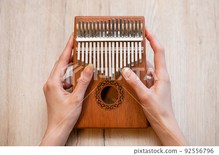 Hands of a woman playing kalimba 92556796