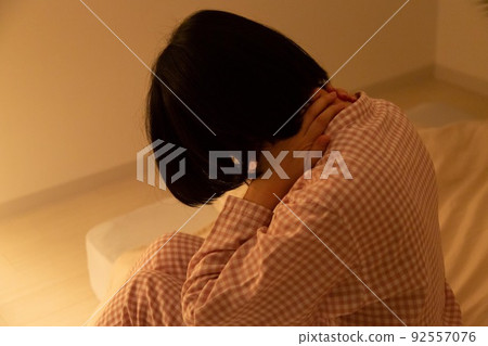Middle-aged woman in pajamas suffering from neck pain 92557076