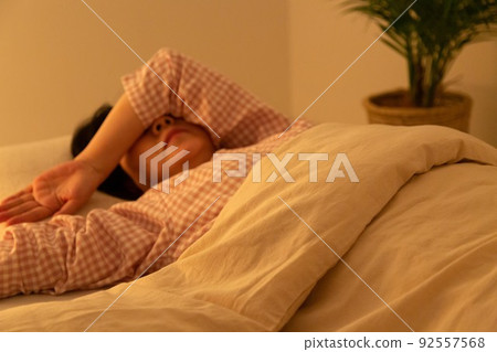 Middle woman wearing pajamas and sleeping on a futon 92557568