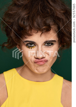 young curly woman with creative make-up in yellow dress 92557885