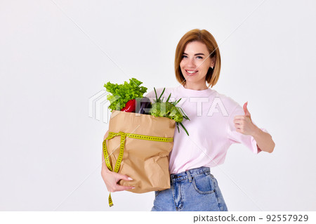 caucasian woman hold paper bag with vegetables 92557929