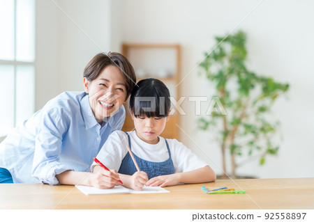 Parents and children (mother and child) doing homework together in the living room Parents and children (mother and child) doing homework together in the living room 92558897