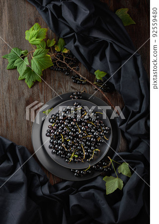 Black currant with leaves on a old wooden table. 92559480