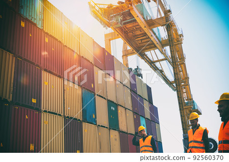Men at work among containers in a commercial port Men at work among containers in a commercial port 92560370