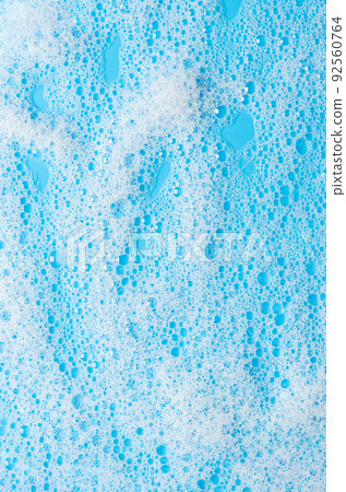 Texture of white foam on a blue background. Cleansing mousse for the face or bath foam or washing powder. Closeup Texture of white foam on a blue background. Cleansing mousse for the face or bath foam or washing powder. Closeup 92560764