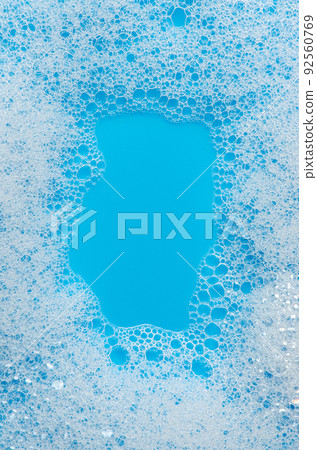 Texture of white foam on a blue background. Cleansing mousse for the face or bath foam or washing powder. Closeup. Copy space Texture of white foam on a blue background. Cleansing mousse for the face or bath foam or washing powder. Closeup. Copy space 92560769