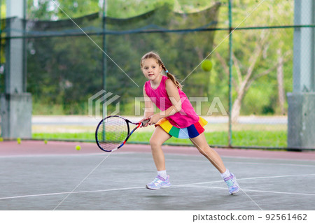 Child playing tennis on outdoor court Child playing tennis on outdoor court 92561462