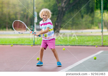 Child playing tennis on outdoor court Child playing tennis on outdoor court 92561463