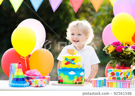 Kids birthday party. Child blowing out cake candle 92561586