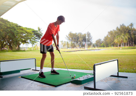 Young man hitting ball on golf driving range. 92561873
