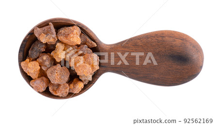 Myrrh resin in wooden spoon, isolated on white background. Pile of natural Commiphora myrrha. Sweet Myrrh Opoponax. Incense. Top view. Myrrh resin in wooden spoon, isolated on white background. Pile of natural Commiphora myrrha. Sweet Myrrh Opoponax. Incense. Top view. 92562169