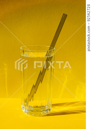 Reusable glass Straws in Glass with water on yellow background Eco-Friendly Drinking Straw Set with cleaning brush. Zero waste, plastic free concept 92562728