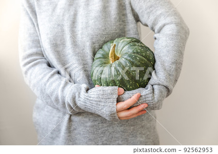 Autumnal Background. Unrecognizable woman hand holding in hands autumn fall pumpkin isolated on white background. Change of seasons ripe organic food, Halloween party Thanksgiving day 92562953