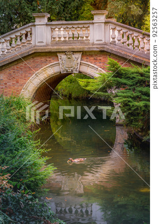 Bridge above pond with reflection in Parc Monceau, Paris, France 92563257