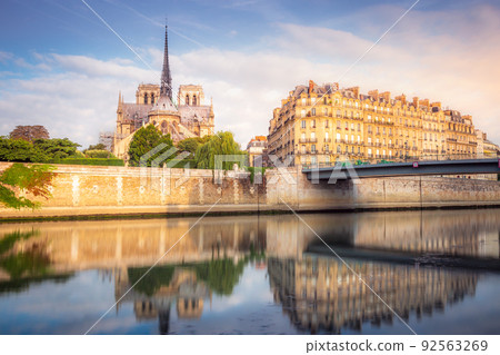 Notre Dame of Paris on Seine River reflection at peaceful sunrise, France 92563269