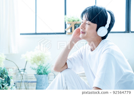 Young man listening to music with headphones Young man listening to music with headphones 92564779
