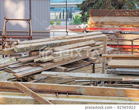 A pile of wooden planks at a construction site. A pile of wooden planks at a construction site. 92565922