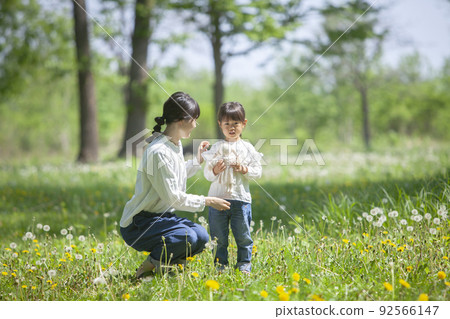 Parents and children playing in the spring field 92566147