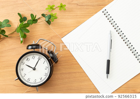 Clock and notebook placed on the desk Clock and notebook placed on the desk 92566315