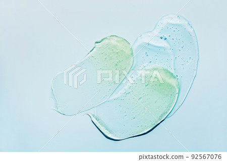 Liquid abstract cosmetic gel smears on blue background. Smear of transparent moisturizing product 92567076