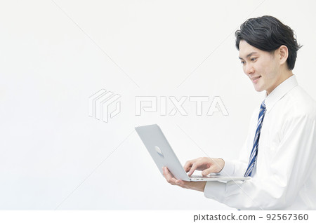 一位商人使用帶複製空間的白色背景筆記本電腦 92567360