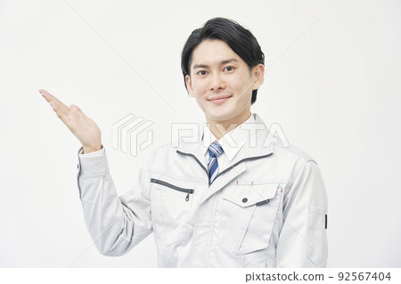 Worker pointing to the left side with his palm on a white background Worker pointing to the left side with his palm on a white background 92567404