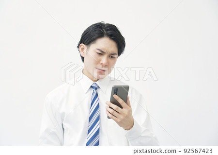 A businessman who has trouble seeing a smartphone with a white background 92567423
