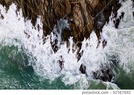 Aerial view Top down seashore big wave crashing on rock cliff Beautiful dark sea surface in sunny day summer background Amazing seascape top view seacoast at Phuket Thailand Aerial view Top down seashore big wave crashing on rock cliff Beautiful dark sea surface in sunny day summer background Amazing seascape top view seacoast at Phuket Thailand 92567892