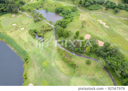 Aerial view drone shot of beautiful green golf field fairway and putting green Top down Aerial view drone shot of beautiful green golf field fairway and putting green Top down 92567976