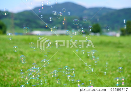 Soap bubble play on green grass 92569747