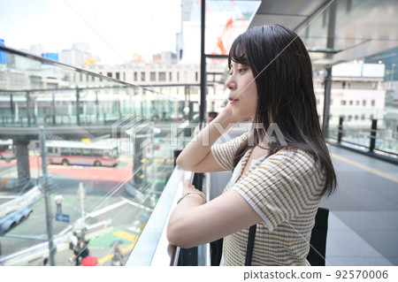A woman looking at the scenery from the second floor of the sidewalk A woman looking at the scenery from the second floor of the sidewalk 92570006