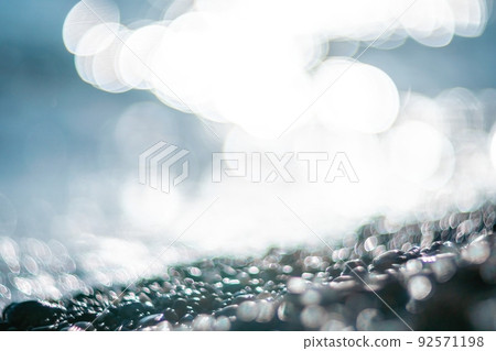 Abstract nature summer ocean sunset sea background. Small waves on water surface in motion blur with bokeh lights from sunrise. Holiday, vacation and recreational background concept. 92571198
